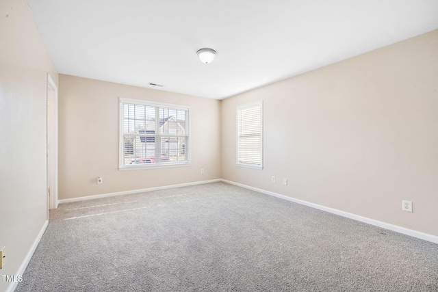 unfurnished room featuring light carpet, visible vents, and baseboards