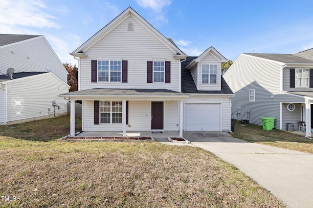 traditional-style home featuring an attached garage, a porch, concrete driveway, and a front yard