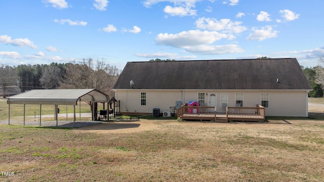 rear view of house featuring a detached carport, a lawn, a wooden deck, and central AC