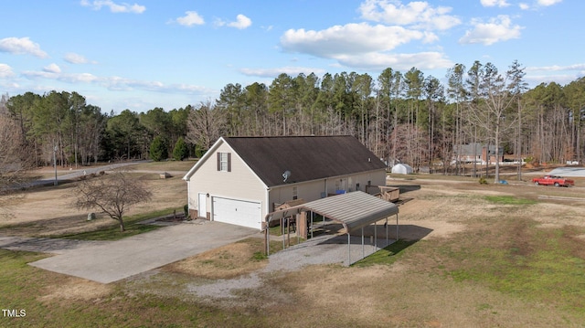 view of front facade with driveway, a forest view, and a garage