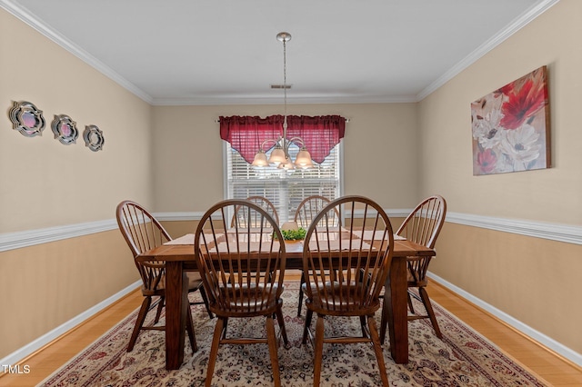 dining space with visible vents, baseboards, a notable chandelier, and wood finished floors