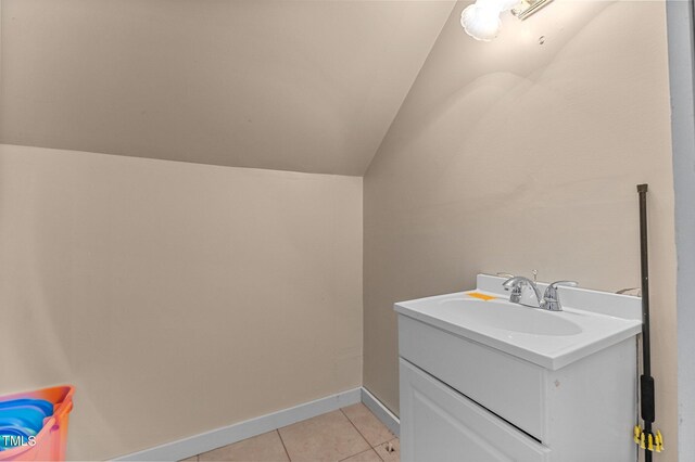 laundry area featuring light tile patterned floors, baseboards, and a sink