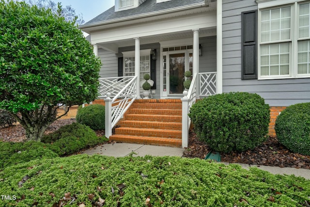 entrance to property featuring a shingled roof