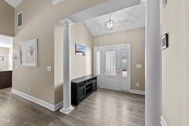 foyer with visible vents, wood finished floors, decorative columns, and baseboards