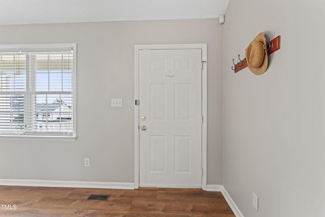 entrance foyer featuring baseboards, visible vents, and wood finished floors