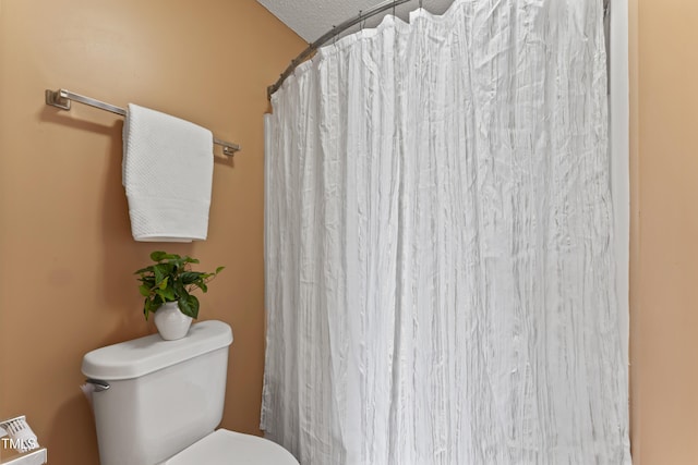 bathroom featuring a shower with curtain and toilet