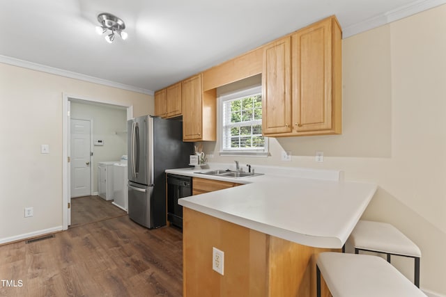 kitchen with visible vents, a sink, separate washer and dryer, dishwasher, and a kitchen bar