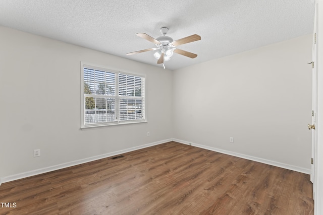 empty room featuring visible vents, ceiling fan, baseboards, and wood finished floors