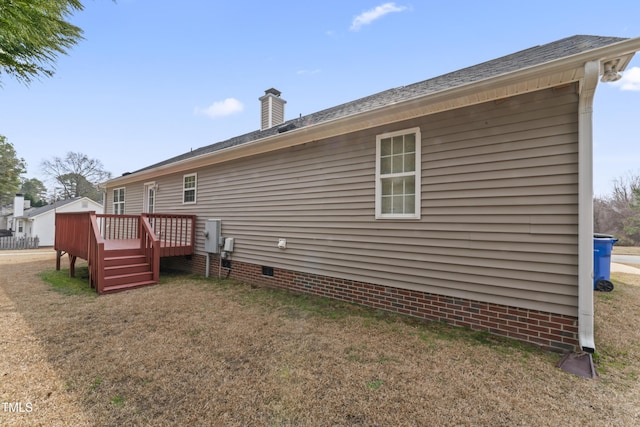 rear view of house with a yard, crawl space, a chimney, and a wooden deck