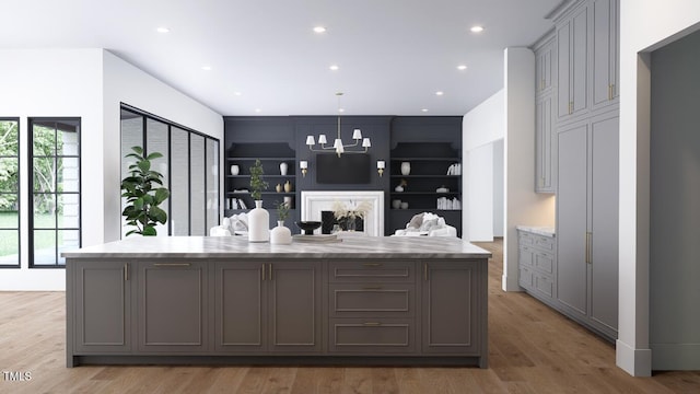 interior space featuring light wood-type flooring, built in features, an inviting chandelier, and recessed lighting