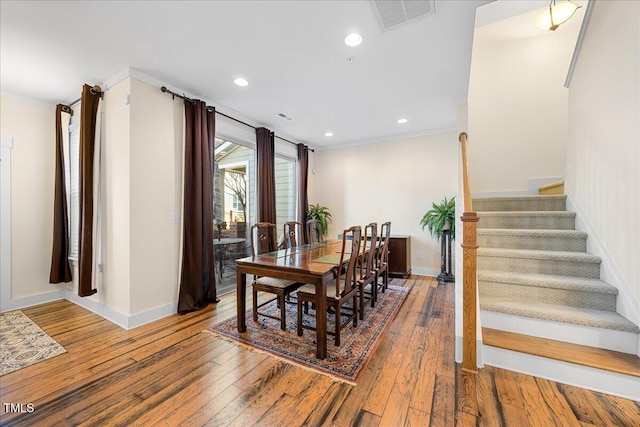 dining area featuring ornamental molding, wood-type flooring, and visible vents