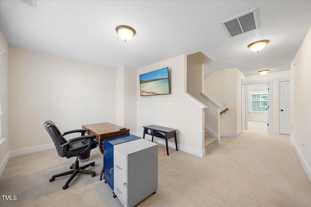 home office with light colored carpet, visible vents, and baseboards