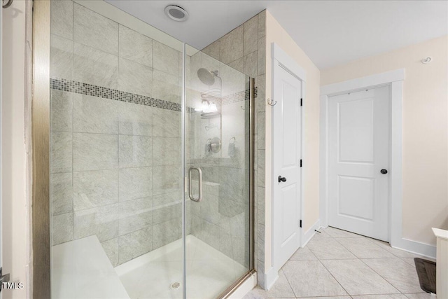 bathroom featuring baseboards, a stall shower, and tile patterned floors