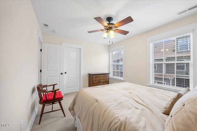 bedroom featuring light carpet, a closet, visible vents, and a ceiling fan