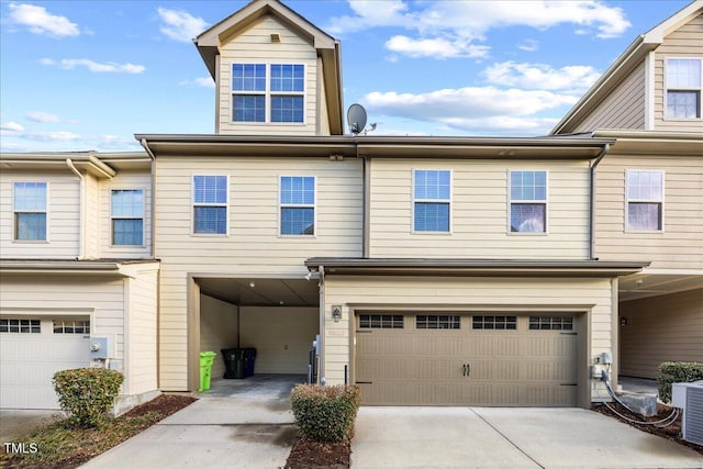 multi unit property featuring driveway, an attached garage, and cooling unit