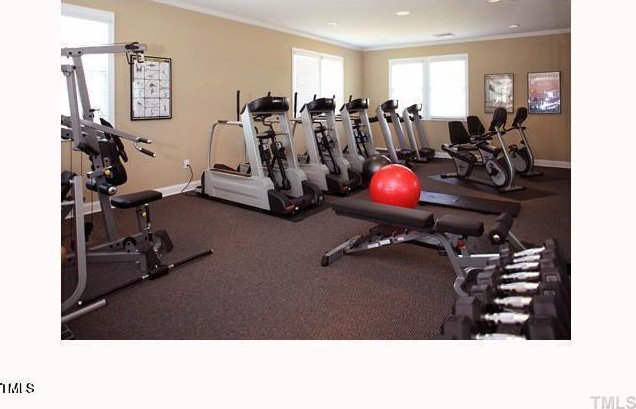 gym featuring ornamental molding and baseboards