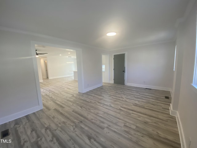 spare room featuring baseboards, ornamental molding, and wood finished floors