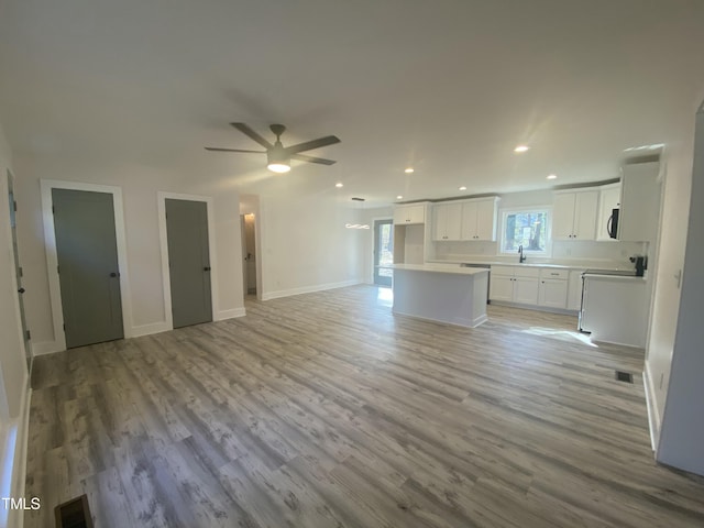 unfurnished living room featuring light wood-style flooring, baseboards, a ceiling fan, and recessed lighting