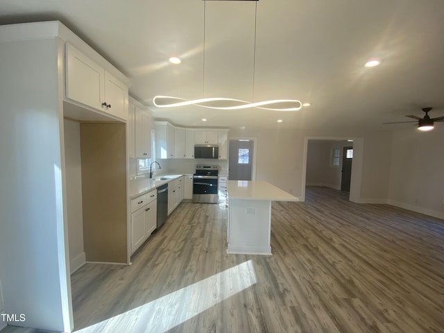 kitchen featuring light countertops, appliances with stainless steel finishes, a sink, and white cabinetry