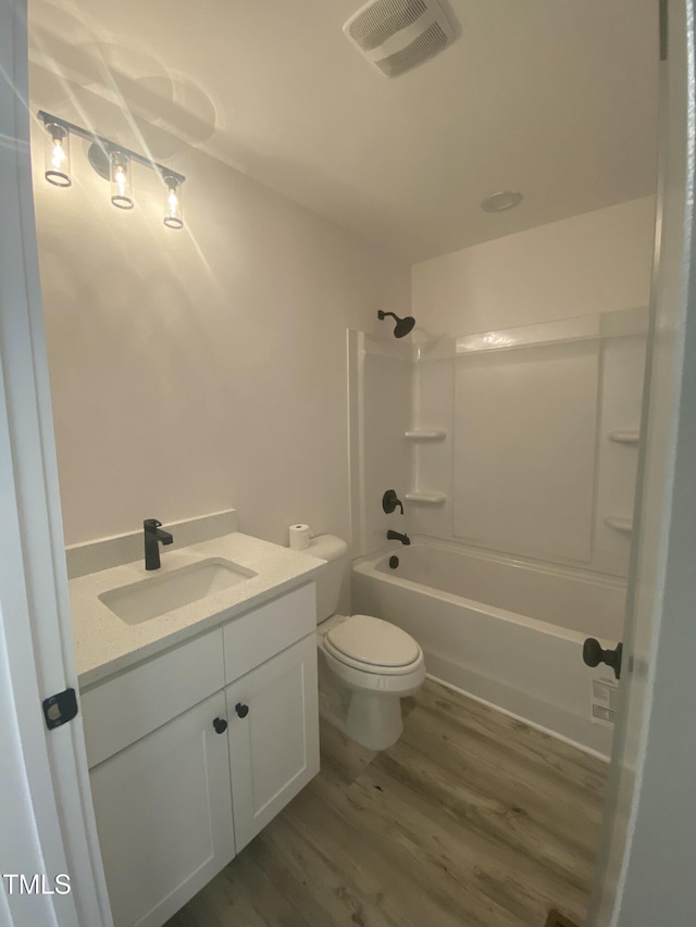 bathroom with shower / tub combination, toilet, wood finished floors, visible vents, and vanity