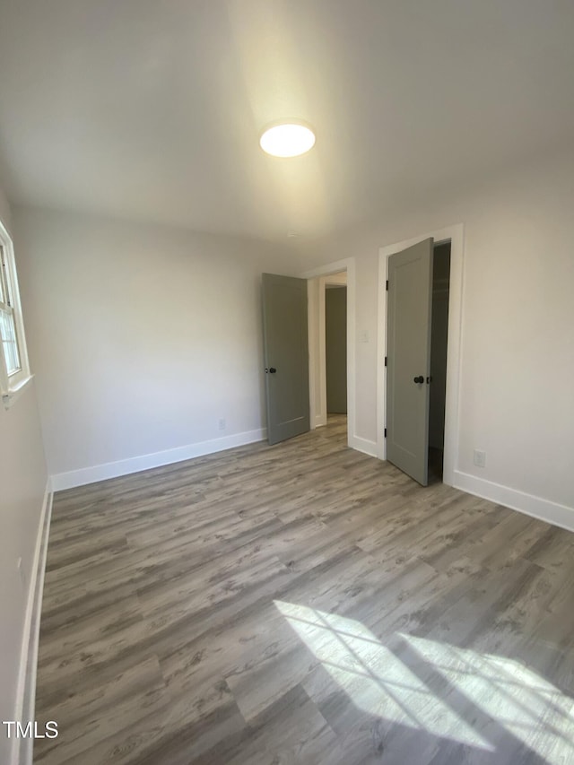 unfurnished bedroom with light wood-style flooring and baseboards