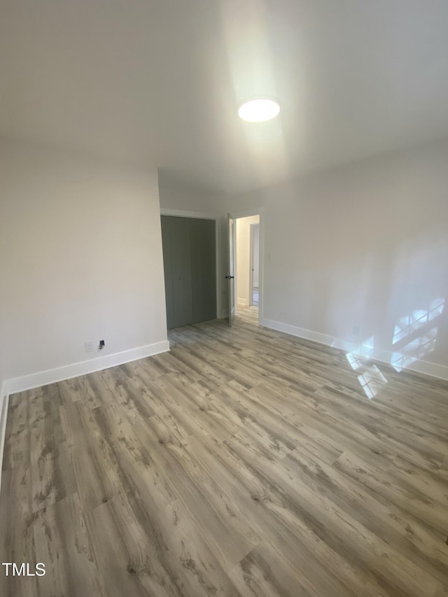 spare room with wood finished floors and baseboards