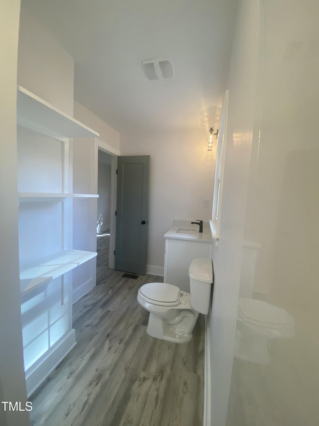 bathroom featuring visible vents, wood finished floors, a sink, and toilet