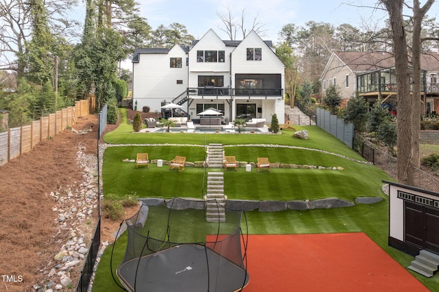 back of property featuring a yard, stairs, and a fenced backyard