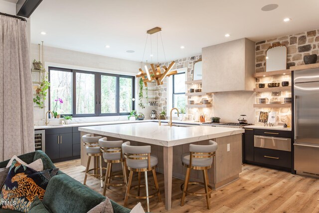 kitchen with open shelves, a warming drawer, built in fridge, and a sink