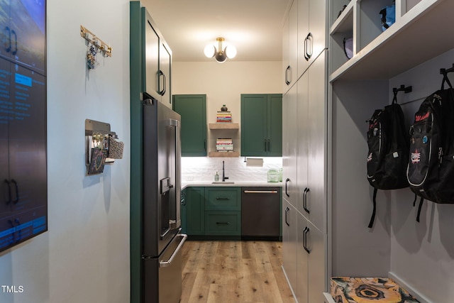 kitchen with green cabinetry, open shelves, dishwasher, and stainless steel refrigerator with ice dispenser