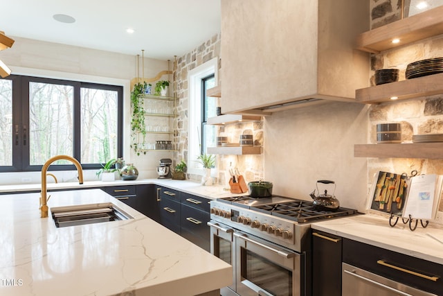 kitchen featuring custom exhaust hood, a sink, dark cabinets, and range with two ovens