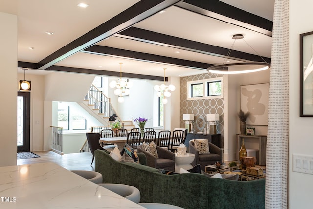 living room with stairs, beam ceiling, a notable chandelier, and wood finished floors