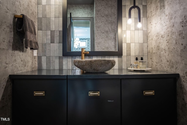 bathroom featuring a sink, tile walls, and double vanity