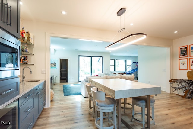 kitchen featuring a sink, light wood-style floors, open floor plan, and recessed lighting