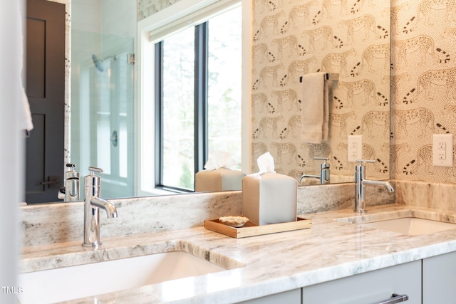 full bathroom with a sink, a healthy amount of sunlight, and double vanity