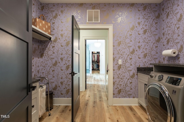 laundry area featuring visible vents, wallpapered walls, light wood finished floors, baseboards, and washer / dryer