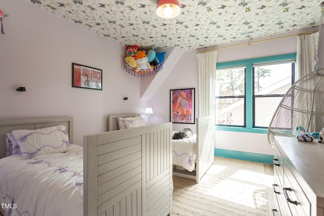 bedroom featuring light colored carpet and baseboards