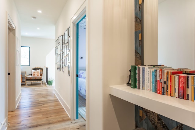 corridor with recessed lighting, baseboards, and light wood-style floors