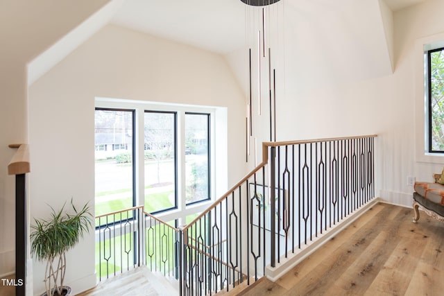 staircase featuring wood finished floors and vaulted ceiling