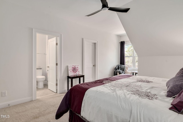 carpeted bedroom with lofted ceiling, ensuite bath, baseboards, and a ceiling fan