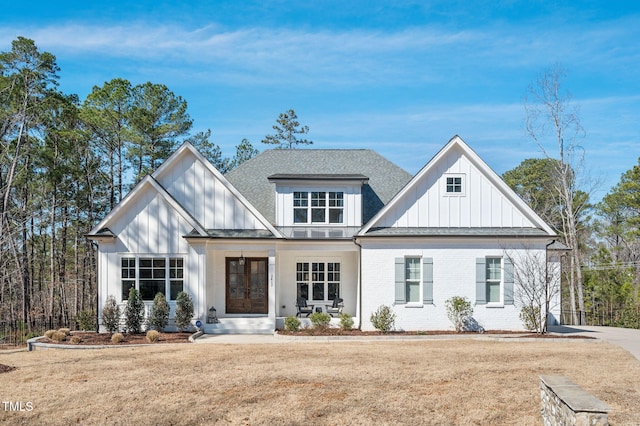 modern inspired farmhouse with brick siding, board and batten siding, and a shingled roof