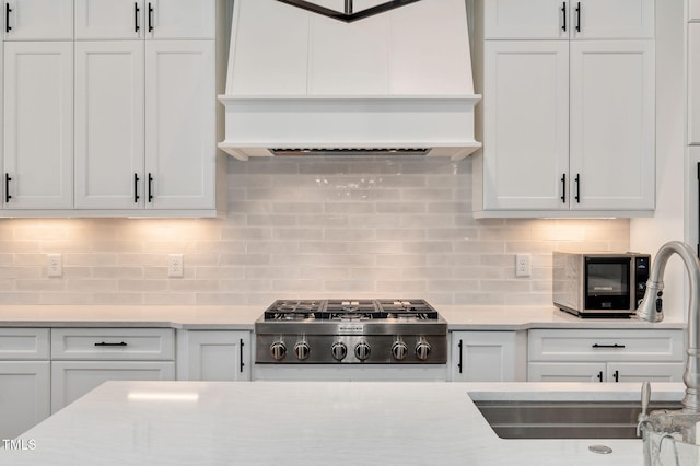 kitchen featuring custom range hood, white cabinets, and stainless steel gas stovetop