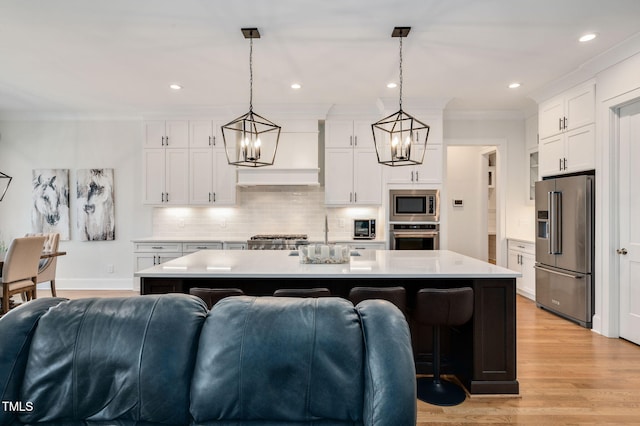 kitchen featuring white cabinets, decorative backsplash, ornamental molding, stainless steel appliances, and light countertops