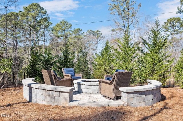 view of patio / terrace with an outdoor fire pit and fence