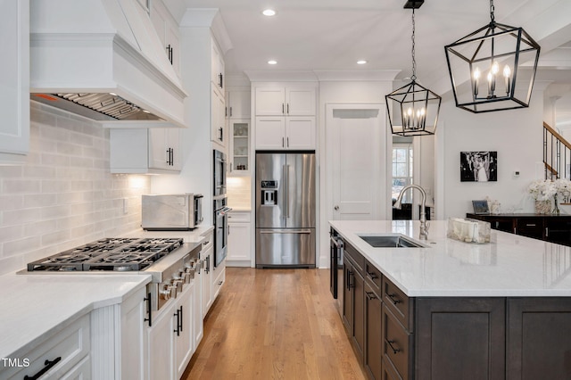 kitchen with appliances with stainless steel finishes, white cabinets, a sink, and custom exhaust hood