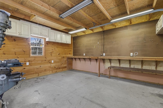 basement featuring a workshop area and wooden walls