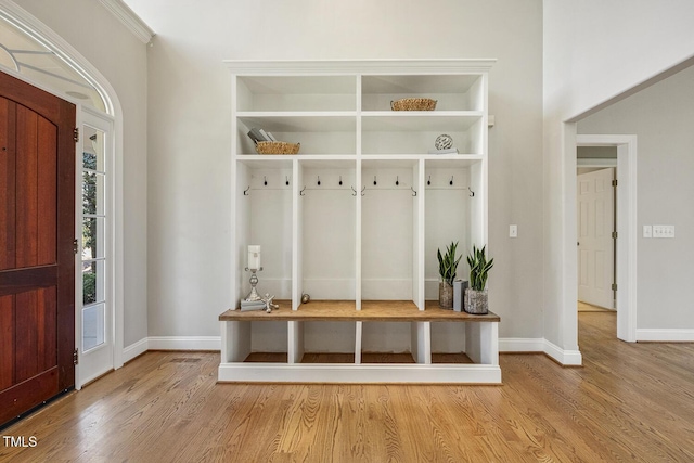 mudroom featuring light wood finished floors and baseboards