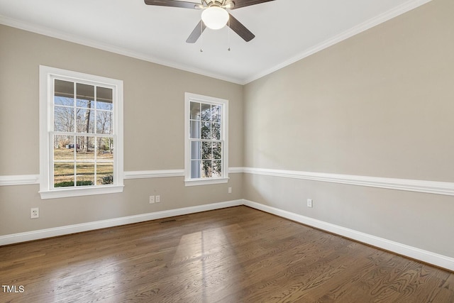 empty room featuring crown molding, baseboards, and wood finished floors