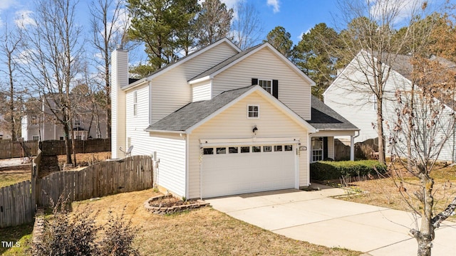 traditional home featuring a garage, concrete driveway, roof with shingles, and fence