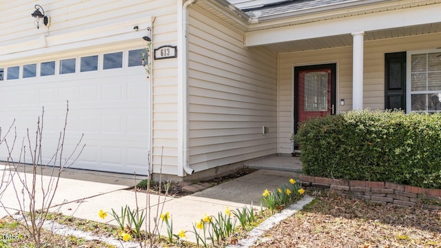 doorway to property featuring a garage and a porch